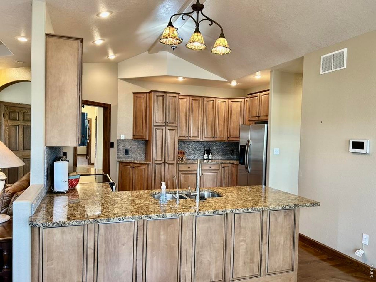 131 Club Road Sterling, CO 80751 - Photo 15 of 50 a kitchen with kitchen island granite countertop wooden cabinets and refrigerator