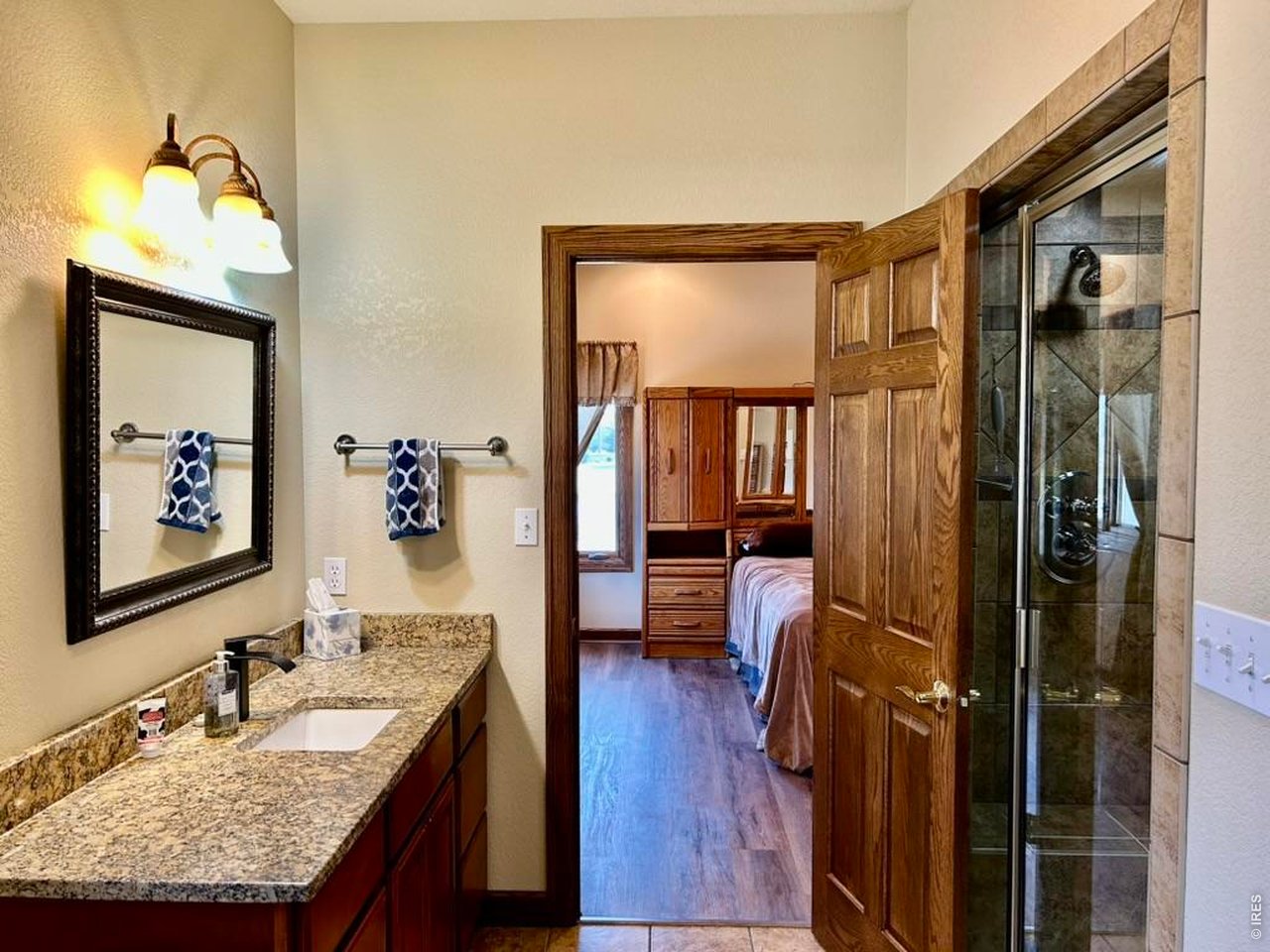 131 Club Road Sterling, CO 80751 - Photo 31 of 50 a en suite bathroom with a granite countertop sink and a mirror
