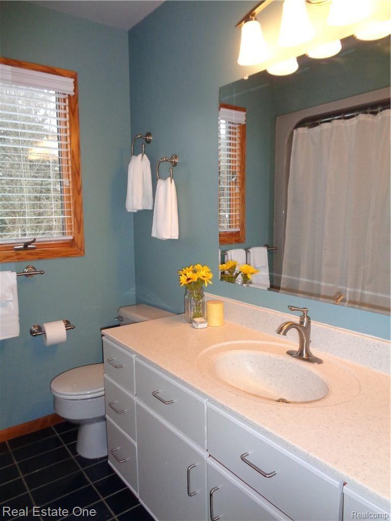 9590 Ridge Top Trail Clarkston, MI 48348 - Photo 38 of 80 Remodeled entry level full bath with painted vanity, new hardware, cultured marble counter with builtin sink, new faucet, fixture, blinds and trendy wall color. All bathrooms had new counters, fixtures, faucets installed 2015, $10k.