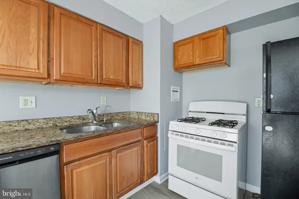a kitchen with granite countertop cabinets stainless steel appliances and a sink