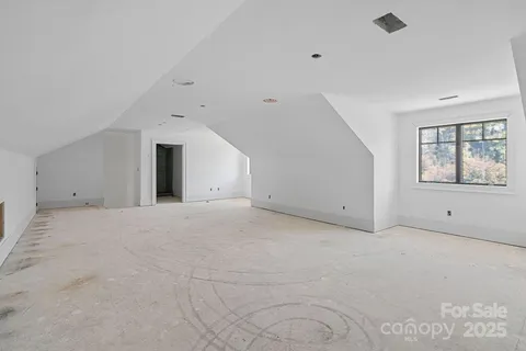 a living room with furniture fireplace and large windows
