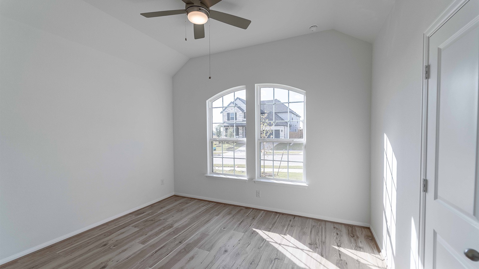 294 Rubber Tree Way Buda, TX 78610 - Photo 16 of 19 Unfurnished room with a ceiling fan, vaulted ceiling, and light wood-style flooring