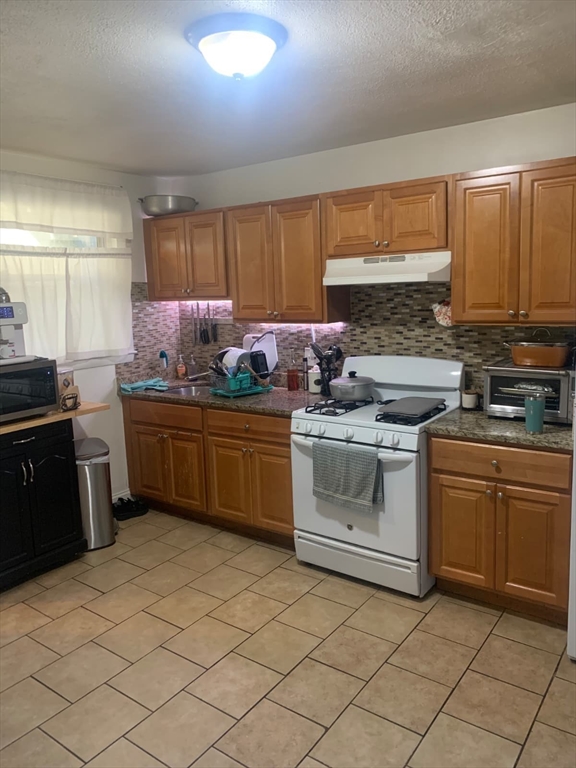 500 Beach Revere Revere Ma, Unit 1 Revere, MA 02151 - Photo 4 of 8 a kitchen with a sink stove and cabinets