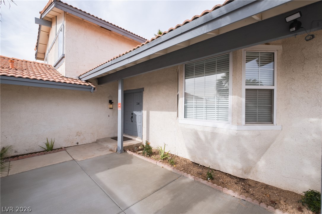 6356 West Viking Road Las Vegas, NV 89103 - Photo 2 of 51 Spanish tile rooflines and textured stucco walls frame a welcoming covered entry path.