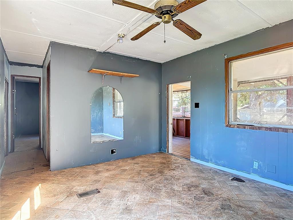 13005 Florida Avenue Astatula, FL 34705 - Photo 11 of 48 a view of a bedroom with a large bed and a chandelier