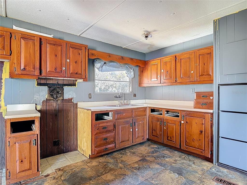 13005 Florida Avenue Astatula, FL 34705 - Photo 14 of 48 a kitchen with stainless steel appliances granite countertop a stove sink and cabinets