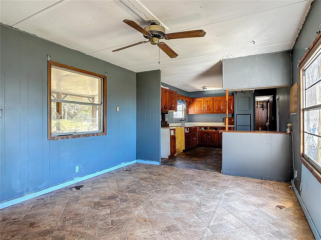 13005 Florida Avenue Astatula, FL 34705 - Photo 10 of 48 a view of a kitchen with a refrigerator a dishwasher cabinets and a large window