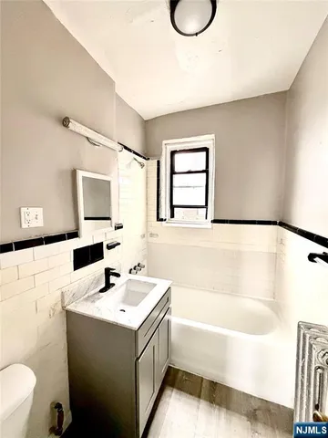 a bathroom with a bathtub a sink and a mirror