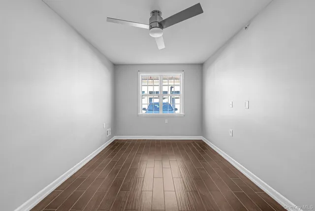 a view of room with wooden floor fan and window