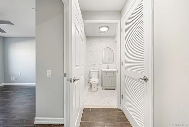 an empty room with wooden floor ceiling fan and windows