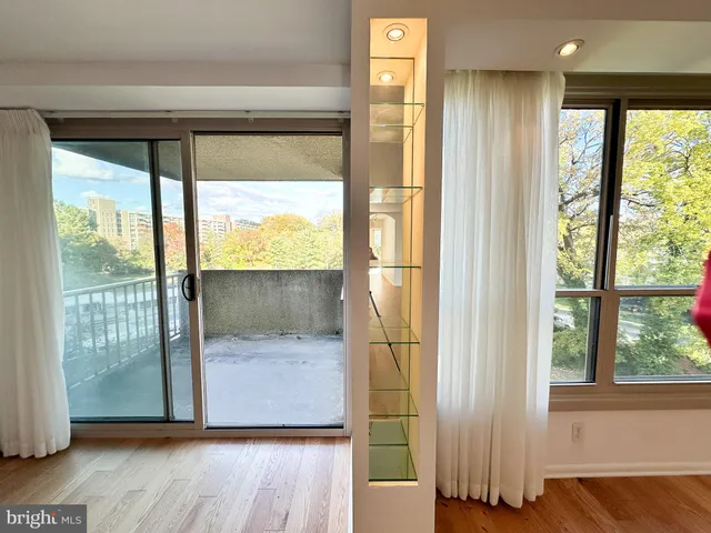 a view of front door and bedroom with wooden floor