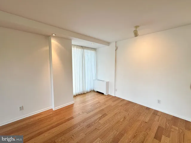 a view of an empty room with wooden floor
