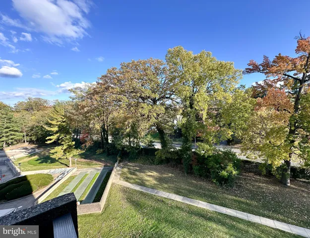 a view of a backyard with lawn chairs under an umbrella