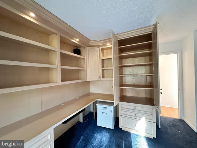 a spacious bathroom with a double vanity sink a toilet a mirror and a glass door shower