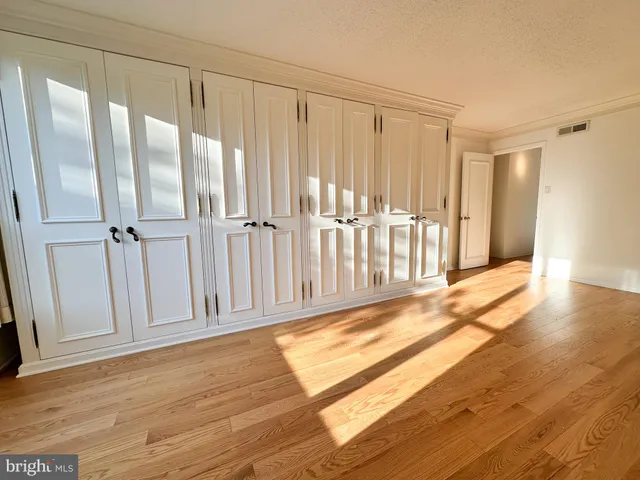 a view of a hallway with wooden floor and stairs