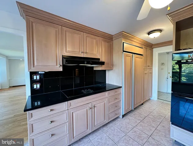 a kitchen with white cabinets and black appliances