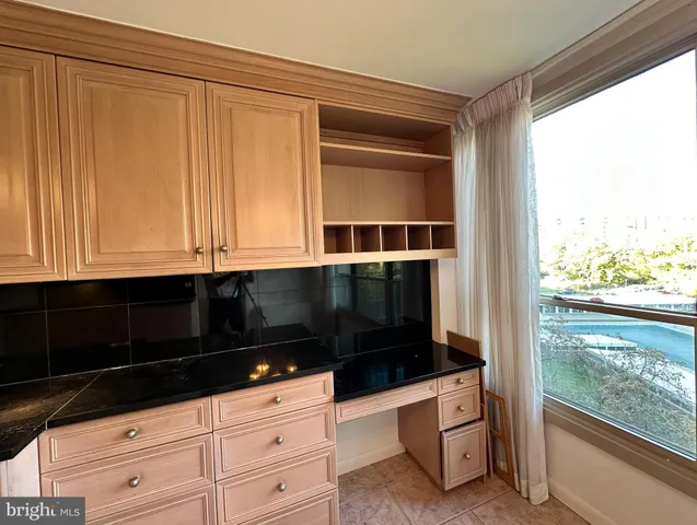 a kitchen with granite countertop white cabinets and sink