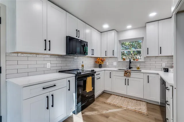 a kitchen with cabinets appliances a sink and a counter top space