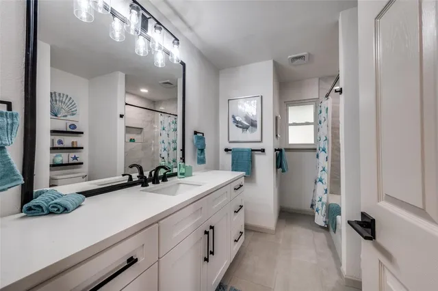 a spacious en suite bathroom with a double vanity sink and a mirror