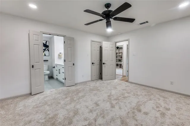 an empty room with closet and a chandelier fan