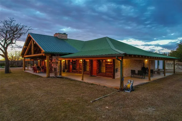 a view of a house with a patio and a yard