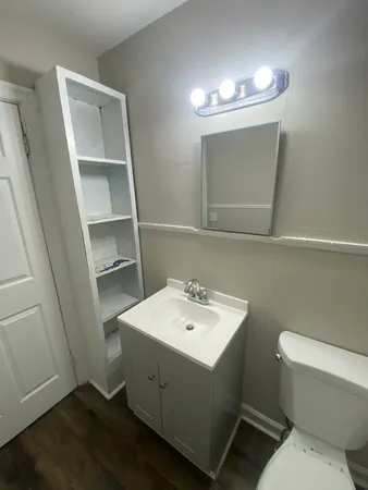 a bathroom with a toilet a sink and mirror