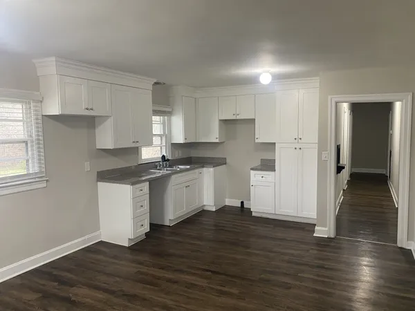 a kitchen with granite countertop white cabinets and white appliances