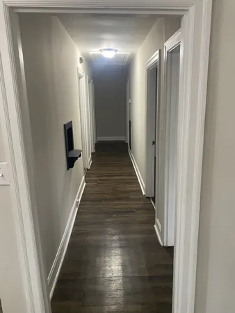 a view of a hallway with wooden floor and staircase
