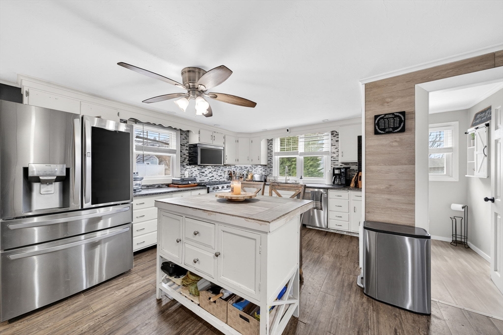 59 Glendale Street Fall River, MA 02720 - Photo 11 of 37 a kitchen with stainless steel appliances kitchen island granite countertop a refrigerator a stove and a sink with wooden floor