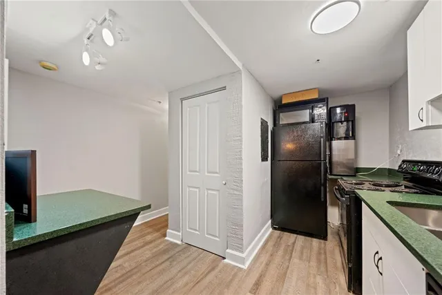 a kitchen that has a lot of cabinets a sink and appliances in it