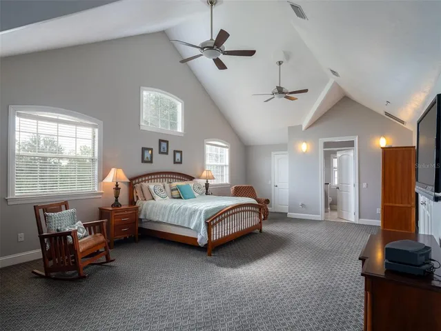 a spacious bedroom with a bed and a chandelier