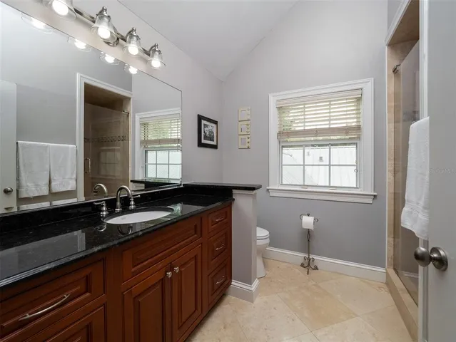 a spacious bathroom with a granite countertop sink a large mirror and a bathtub
