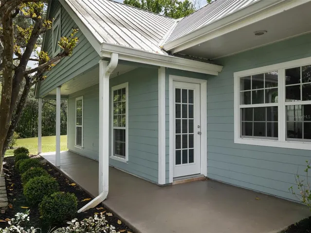 a view of a house with backyard and sitting area