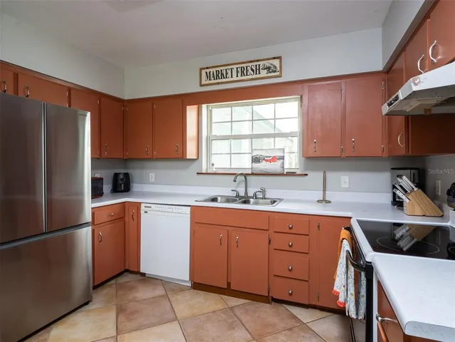 a kitchen with a refrigerator sink and cabinets