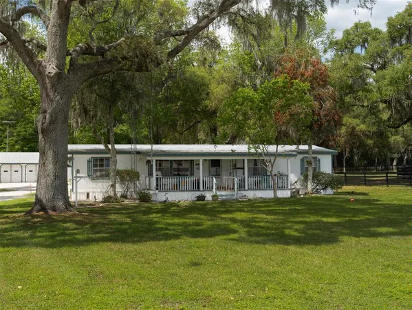 a front view of a house with a garden and trees