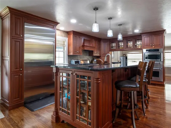 a kitchen with stainless steel appliances granite countertop a refrigerator and a stove top oven