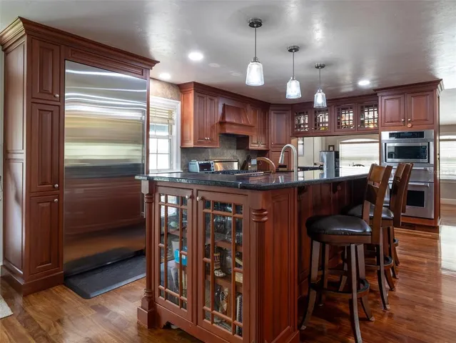 a kitchen with stainless steel appliances granite countertop a refrigerator and a stove top oven