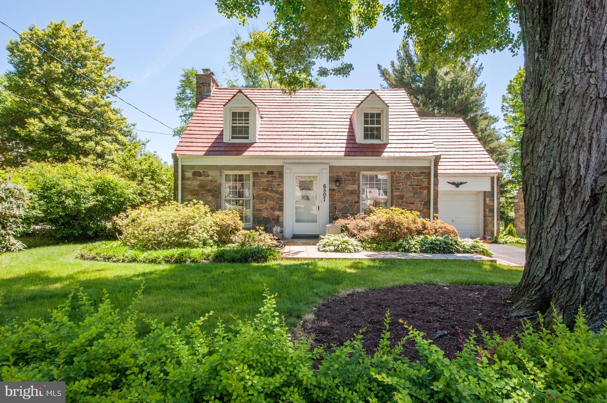 6507 Sharon Road Baltimore, MD 21239 - Photo 1 of 19 a front view of a house with a garden and trees