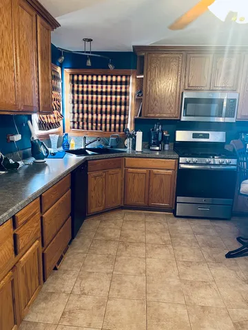 a kitchen with stainless steel appliances granite countertop a sink stove and cabinets