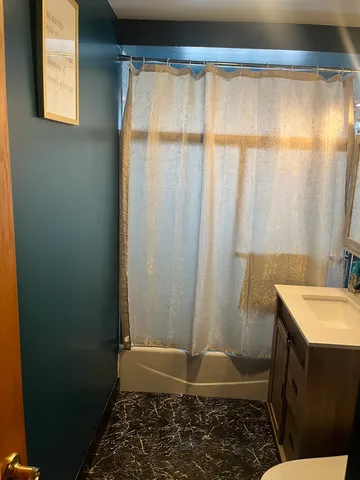 a bathroom with a shower curtain and a sink