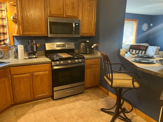 a kitchen with stainless steel appliances granite countertop a stove a sink and a microwave
