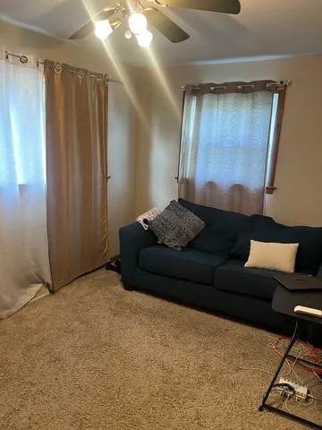 a living room with furniture and a air conditioner vent
