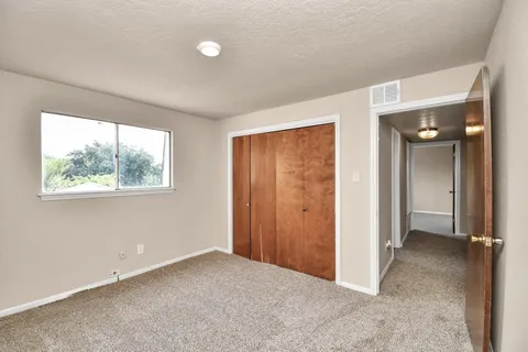 an empty room with windows and closet