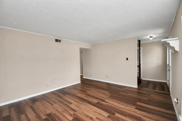 a view of an empty room with wooden floor