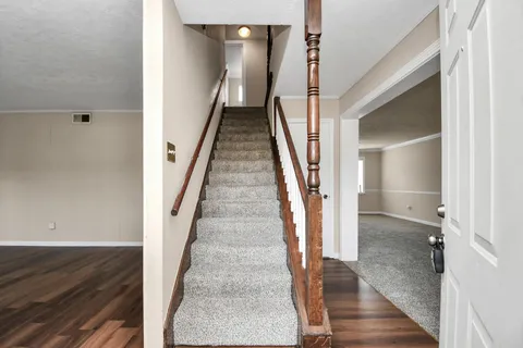 a view of a hallway with wooden floor and entryway
