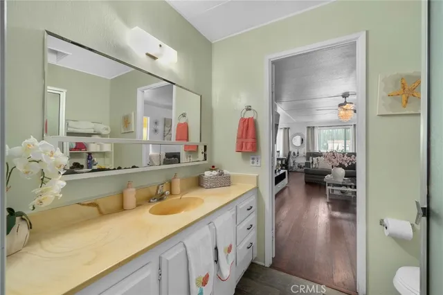 a bathroom with a granite countertop sink a toilet and a shower