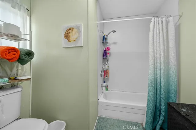 a large bedroom with a bed and wooden floor