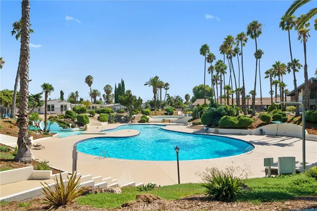 a view of a swimming pool with a chair and tables in the patio