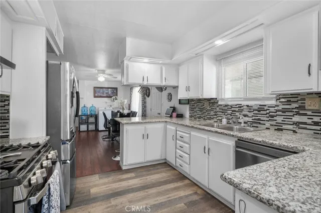 a kitchen with granite countertop a refrigerator stove and sink