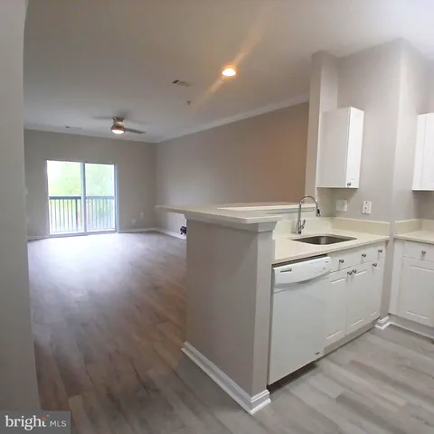 a kitchen with a sink cabinets and wooden floor
